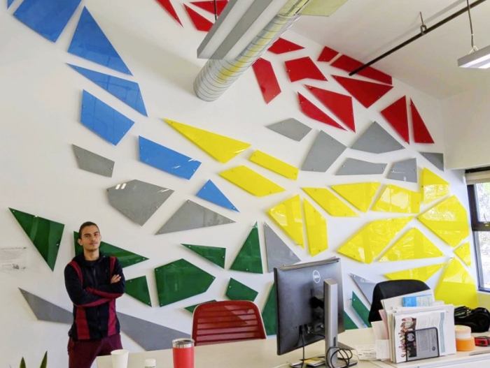 man standing next to wall art