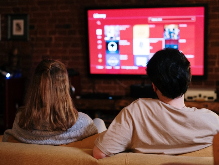 2 people on couch watching tv