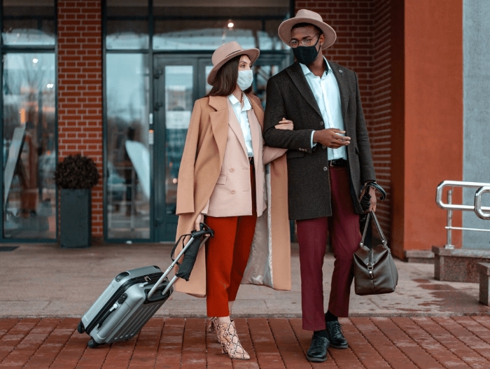 man and women holding travel bags