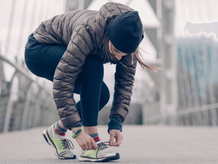 women bending over to tie shoes